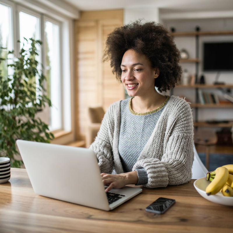 black woman sitting at laptop smiling